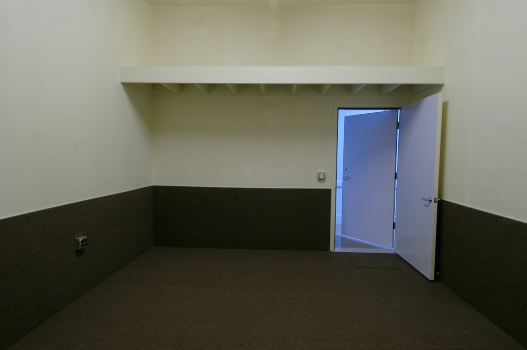 An empty rehearsal room with a storage loft